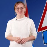 Mirjam Benecke vor einen Plakat mit AFD-Verbot.