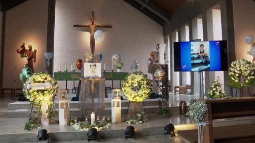 Ein Altar mit Blumen, Luftballons und einem Bild des verstorbenen Arian in der Mitte.