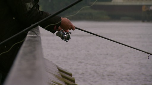 Eine Person angelt in der Weser in Vegesack.