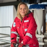 Antje Boetius sitzt in Arbeitskleidung auf einer Treppe an Bord der Polarstern