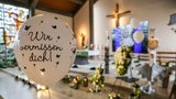 Ein Luftballon mit der Aufschrift "Wir vermissen dich!" schwebt bei der Trauerfeier für Arian aus Bremervörde vor einem mit Blumen geschmückten Altar.
