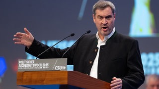 Ein Mann, Markus Söder, steht an einem Rednerpult und gestikuliert.