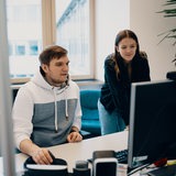 Zwei junge Menschen in einem Büro an einem Schreibtisch