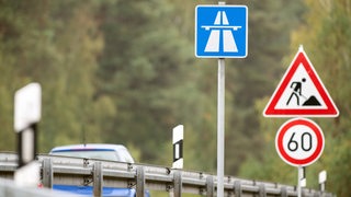 Verkehrsschilder signalisieren eine Baustelle auf einer Autobahn.