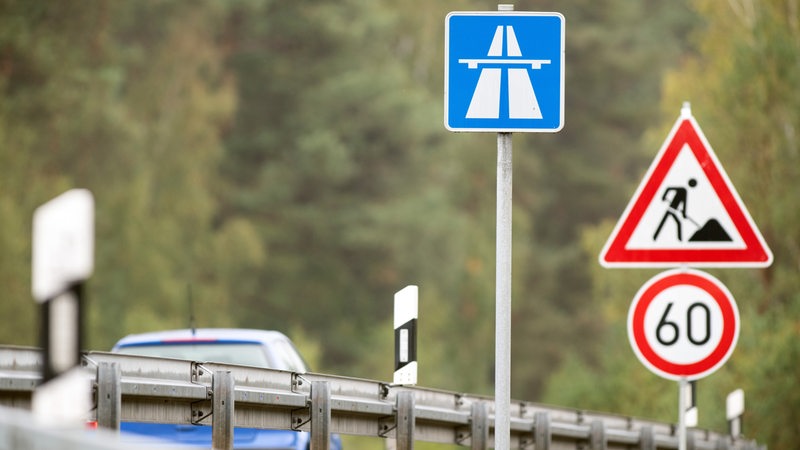 Verkehrsschilder signalisieren eine Baustelle auf einer Autobahn.