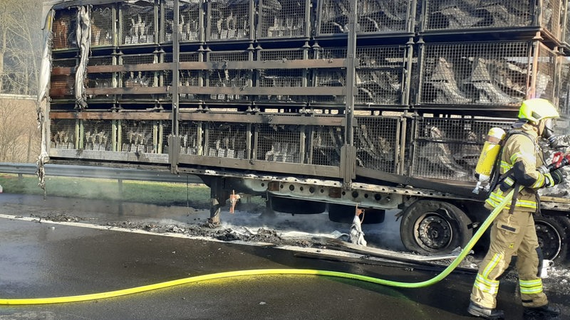 Ein ausgebrannter Lkw-Anhänger steht auf einer Autobahn.