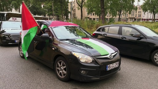 Ein mit Palästinensischen Flaggen geschmücktes Auto wärend eines Autokorsos.