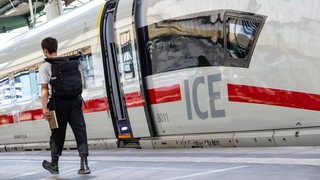 Ein Mann läuft auf dem Bahnsteig neben einem ICE.