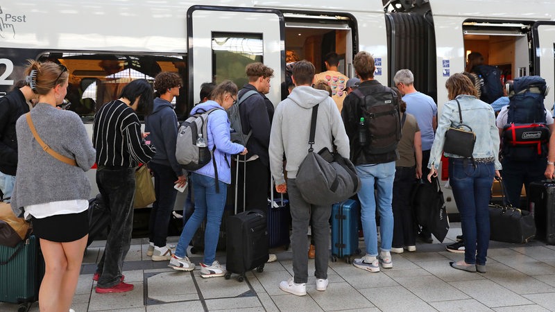 Passagiere steigen in einen ICE-Zug ein.