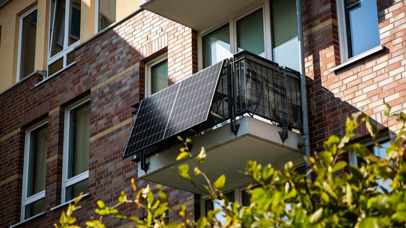 Auf dem Balkon eines Hauses sind Solarzellen zu sehen.