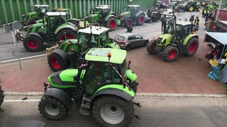 Zu sehen sind Traktoren, welche eine Straße blockieren.