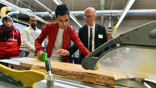 Ein Junger Mann aus dem Irak bei seiner Berufsausbildung arbeitet an einer Hobelbank