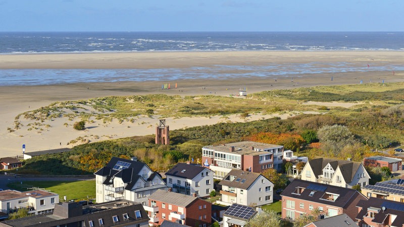 Blick vom Neuen Leuchtturm über Gebäude des Ortes und dem Kleinen Kaap und den weiten Strand zur See auf Borkum