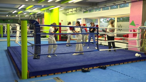 Mädchen üben Boxen in einem Trainingsraum.