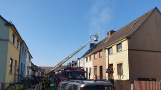 Die Feuerwehr löscht mit einem Leiterwagen einen Brand in einem Haus in Bremen-Gröpelingen.