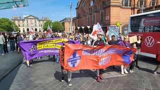 Demonstranten mit Bannern vor dem Bremer Bahnhof