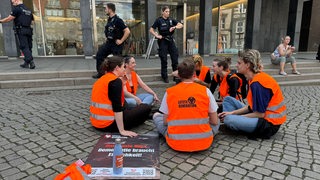 Protestierende der letzten Generation sitzen im Kreis vor der Bremer Bürgerschaft