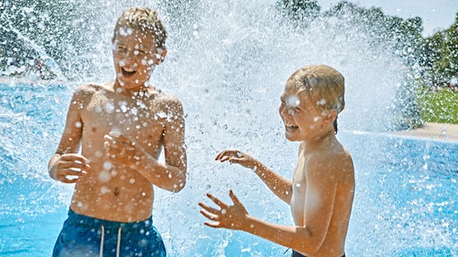 2 Jungen in einer Wasserfontäne im Bremer Schlosspark Freibad