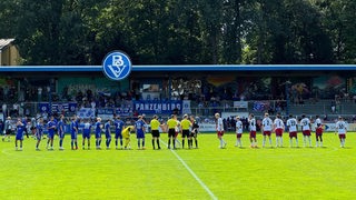 Die Spieler des Bremer SV und Hamburger SV II klatschen sich vor der Partie ab.