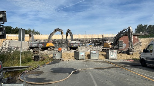 Drei Bagger vor dem Schutt einer Autobahnbrücke