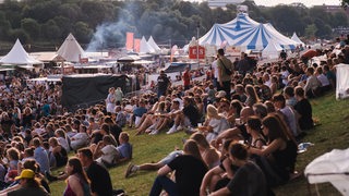 Festival-Besucher sitzen auf dem Osterdeich während der Breminale 