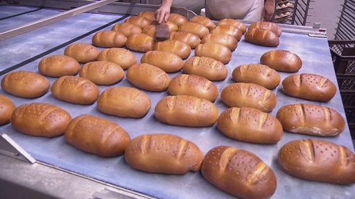 Mehrere gebackene Brötchen auf einem Tisch in der Backstube.