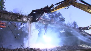 Bagger reißt eine Brücke ab.