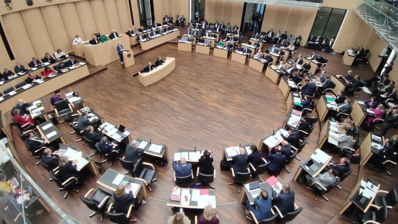 Bei einer Sitzung im Bundesrat hören die Teilnehmer einer Rednerin zu.