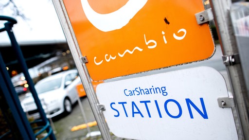 Ein Schild mit der Aufschrift "CarSharing Station" steht an einem Parkplatz.