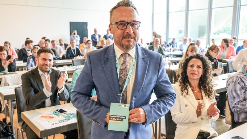 Heiko Strohmann, Landesvorsitzender der Bremer CDU, steht nach seiner Wiederwahl beim Landesparteitag der CDU Bremen vor applaudierenden Delegierten.
