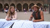 Zwei junge Menschen sitzen im Rahmen des "Alterniv-City-Gipfels" an einem Tisch vor dem Rathaus.