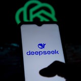 Fotomontage zeigt das "deepseek"-Logo auf einem Mobiltelefon vor dem Logo von Open AI im Hintergrund