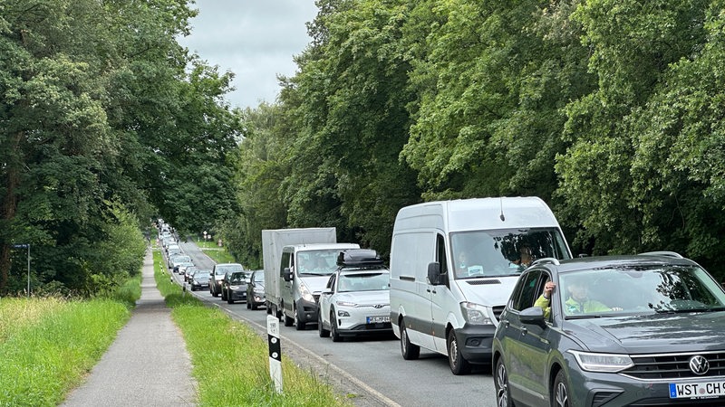 Auf einer Landstraße stauen sich zahlreiche Autos.