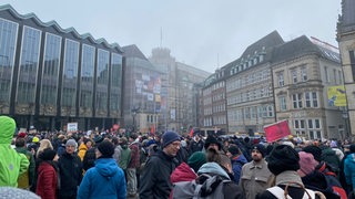 Zahlreiche Menschen stehen auf dem Bremer Marktplatz, im Hintergrund die Bürgerschaft.