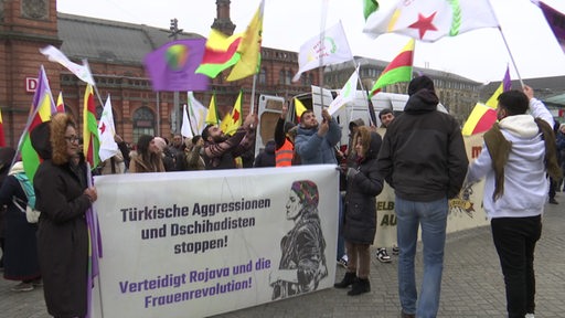 Menschen demonstrieren vor dem Bremer Hauptbahnhof.