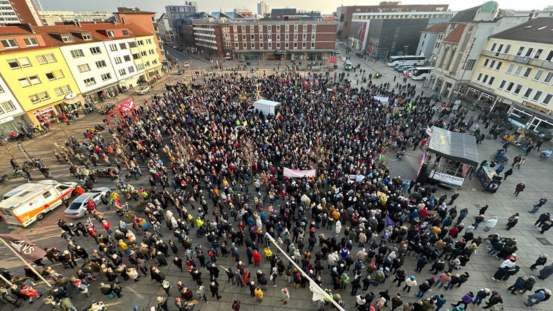 Eine Menschenmenge steht vor einer Bühne in Bremerhaven als Teil einer Demo.