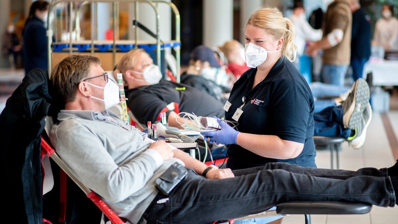 An employee of the DRK is talking to a man who has donated blood (archive picture)