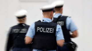 Drei Bundespolizisten sind von hinten zu sehen.