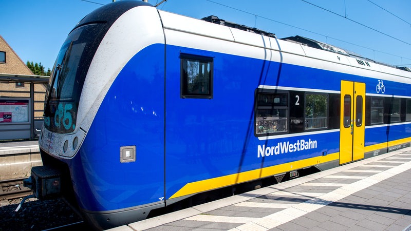 Ein Zug der Nordwestbahn steht an einem Bahnsteig.