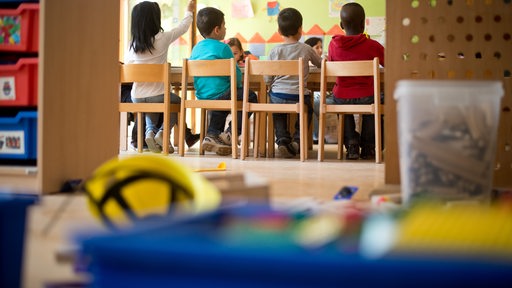 Kinder sitzen in einer Kita am Tisch (Symbolbild)