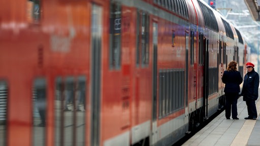 Ein Regionalexpress der Deutschen Bahn steht im Bahnhof am Bahnsteig.