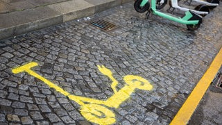 Ein gelbes Symbol markiert einen Abstellplatz für Elektro-Roller.