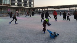 Schlittschuhläufer auf der neuen Eisbahn in der Bremer Überseestadt.