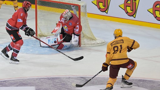 Eishockey-Torwart Maximilian Franzreb verteidigt einen Schuss eines Genfer Spielers im Viertelfinale der Champions Hockey League.