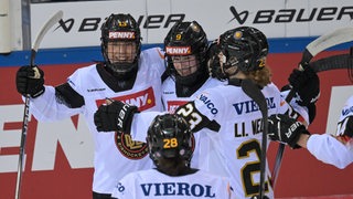 Die Eishockey-Spielerinnen der deutschen Nationalmannschaft liegen sich nach einem Treffer jubelnd in den Armen.