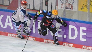 Eishockey-Profi Nicolas Appendino (Fischtown Pinguins) weicht dem Tackling von Kyle Platzer (Schwenninger Wild Wings) an der Bande aus.