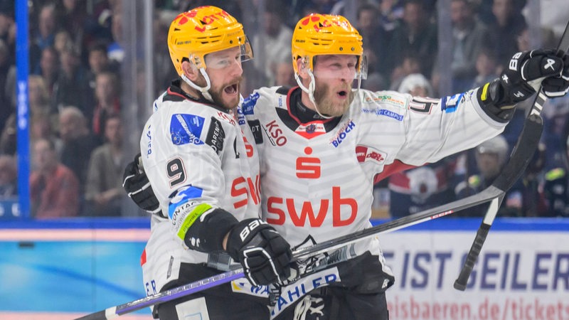 Die Eishockey-Spieler Jan Urbas und Nicholas Jensen liegen sich jubelnd in den Armen nach einem Treffer im Finale.