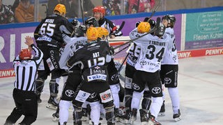 Beim Eishockeyspiel zwischen den Fischtown Pinguins und den Kölner Haien hat sich eine Spielertraube gebildet.