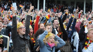Fans verfolgen bei der WM 2014 ein Spiel des DFB-Teams beim Public Viewing auf der Galopprennbahn und freuen sich über ein Tor. 