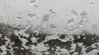 Schneeflocken auf einem Fenster, im Hintergrund schemenhaft das Weserstadion